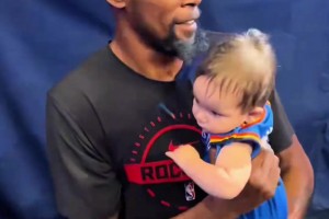 杜兰特抱着雷霆粉丝的孩子，看不出来手法还挺专业的
